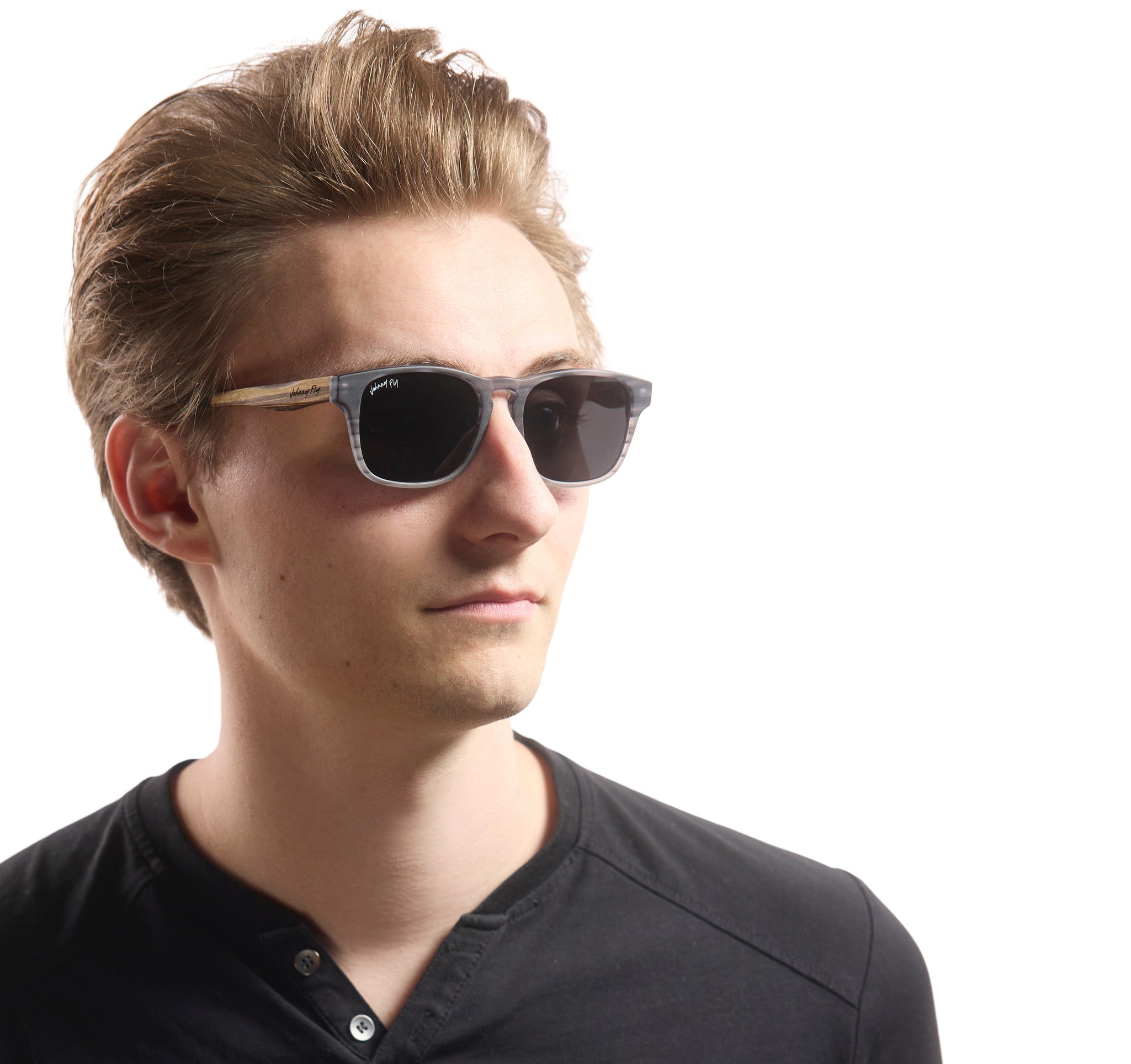 A person wearing Johnny Fly &quot;Splinter&quot; sunglasses featuring a sleek combination of an acetate front section, wooden arms, and nylon polarized lenses.